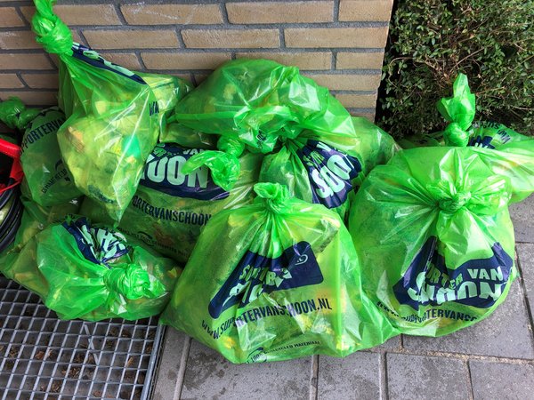 Groene vuilniszakken met zwerfafval